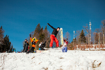 Image showing Bukovel, Ukraine - December 22, 2016: Man boarder jumping on his snowboard against the backdrop of mountains, hills and forests in the distance. Bukovel, Carpathian mountains