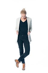 Image showing Casual, relaxed, business woman looking down, standing against white background.