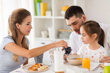 Image showing happy family having breakfast at home