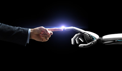 Image showing robot and human hand flash light over black