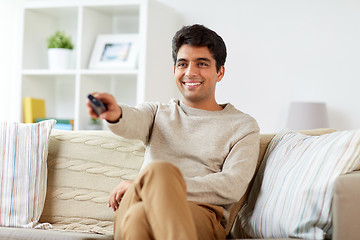 Image showing man with remote control watching tv at home