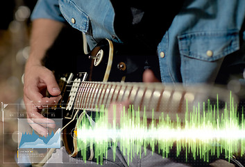 Image showing close up of musician playing guitar at studio