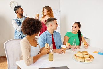 Image showing happy friends or team eating at office