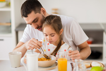 Image showing happy family eating flakes for breakfast at home