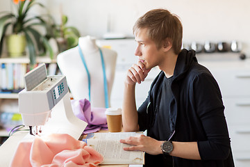 Image showing fashion designer reading book at studio