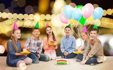 Image showing happy children in party hats with birthday cake