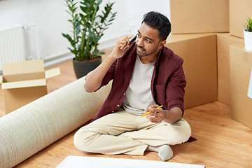 Image showing man with blueprint and boxes moving to new home