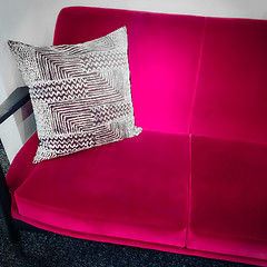 Image showing Vibrant pink velvet sofa with ornamental cushion