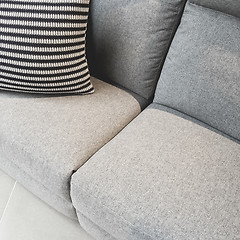 Image showing Striped cushion decorating a gray textile sofa