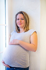 Image showing Pregnant woman standing near window