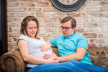 Image showing Happy pregnant woman and man sitting near wall