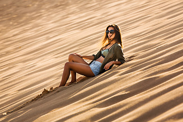 Image showing Young girl lying on a sand dune