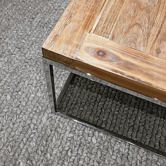 Image showing Modern wooden table on gray knitted carpet