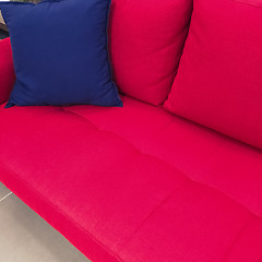 Image showing Blue cushion on a red sofa