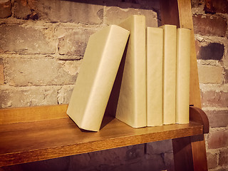 Image showing Books on a wooden shelf near a brick wall