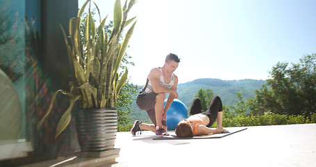 Image showing Couple Doing Stretching Exercises Together in front of luxury vi