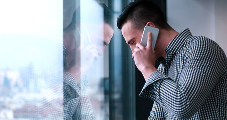 Image showing Business Man Talking On Cell Phone, Looking Out Office Window