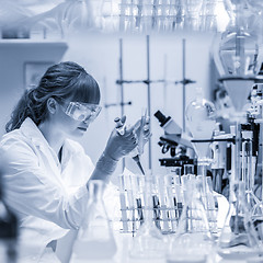 Image showing Young scientist pipetting in life science laboratory.