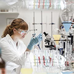 Image showing Young scientist pipetting in life science laboratory.