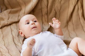 Image showing sweet little baby boy lying on knitted blanket