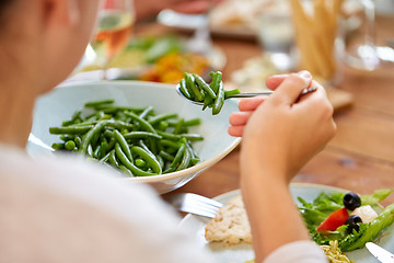 Image showing close up of woman eating green beans