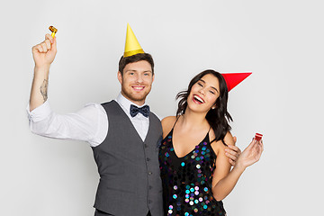 Image showing happy couple with party blowers having fun