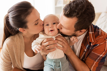 Image showing happy mother and father kissing baby at home