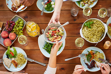 Image showing people eating salad at table with food