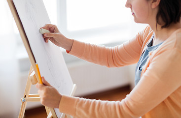 Image showing artist with eraser drawing picture at art studio