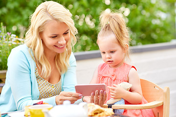 Image showing mother and daughter with smartphone at cafe