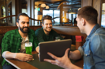 Image showing friends with tablet pc and green beer at pub