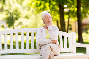 Image showing sad senior woman sitting on bench at summer park