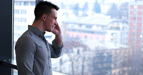 Image showing Business Man Talking On Cell Phone, Looking Out Office Window