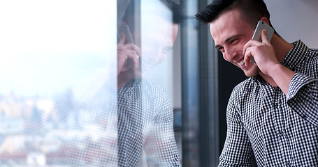 Image showing Business Man Talking On Cell Phone, Looking Out Office Window