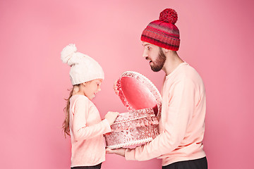 Image showing Portrait of a surprised little girl with her father holding a Christmas present