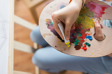 Image showing artist applying paint to palette at art studio