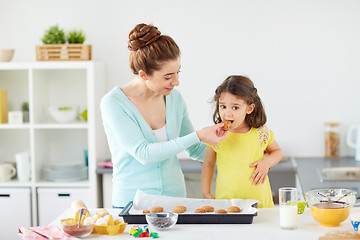 Image showing happy mother and daughter baking cookies at home