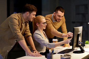 Image showing business team with computer working late at office