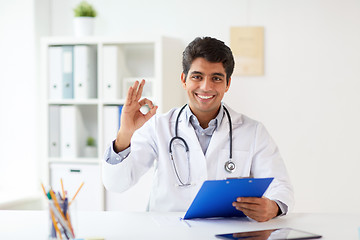 Image showing happy doctor with clipboard at clinic showing ok