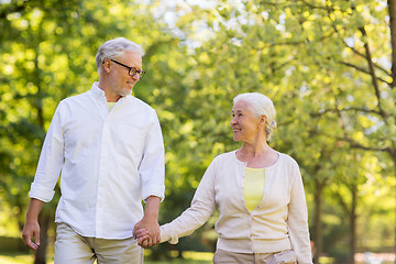 Image showing happy senior couple walking at summer park