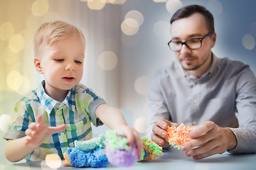 Image showing father and son playing with ball clay at home