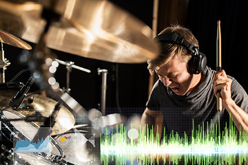 Image showing male musician playing drum kit at concert