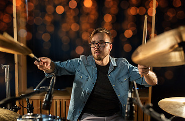 Image showing musician playing drum kit at concert over lights