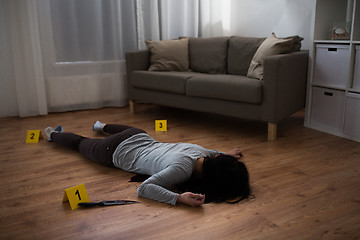 Image showing dead woman body lying on floor at crime scene