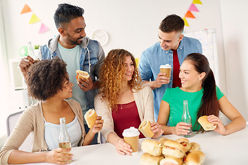 Image showing happy friends or team eating at office party