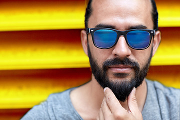 Image showing close up of man in sunglasses touching beard