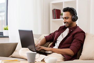 Image showing man in headphones with laptop listening to music