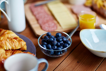 Image showing bowl of blueberries on wooden table at breakfast