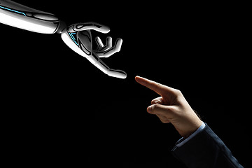 Image showing robot and human hand connecting fingers