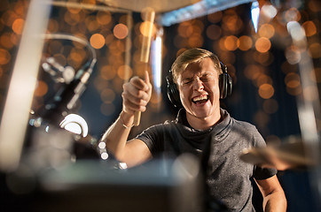 Image showing musician playing drum kit at concert over lights